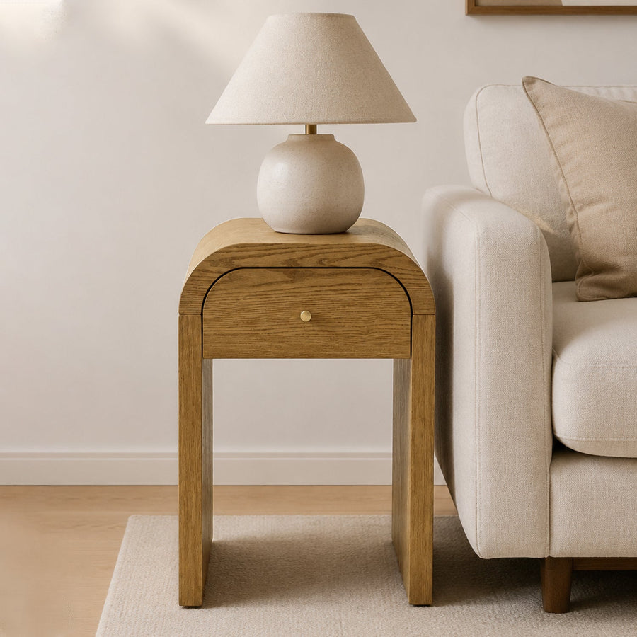 Curved Side Table with Drawer beside a sofa with a table lamp