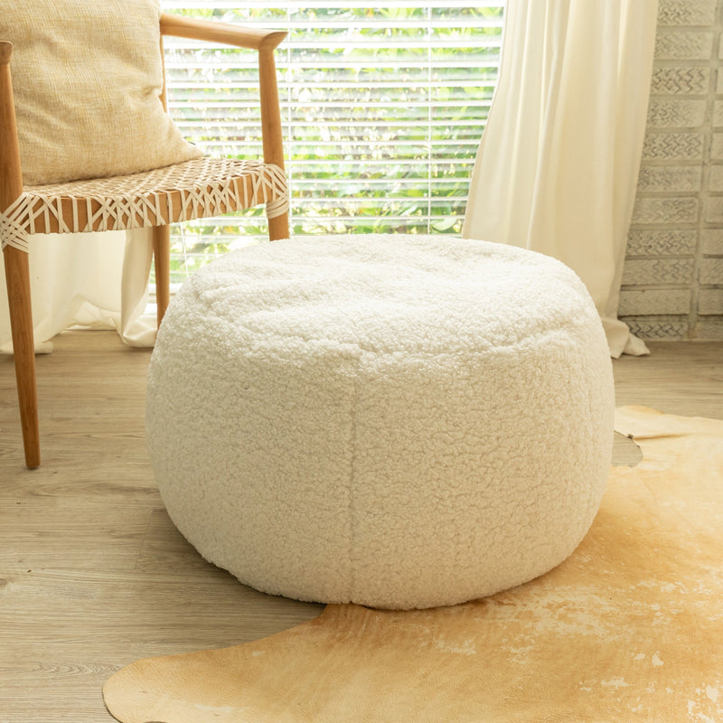 White textured ottoman in a room with a chair and window