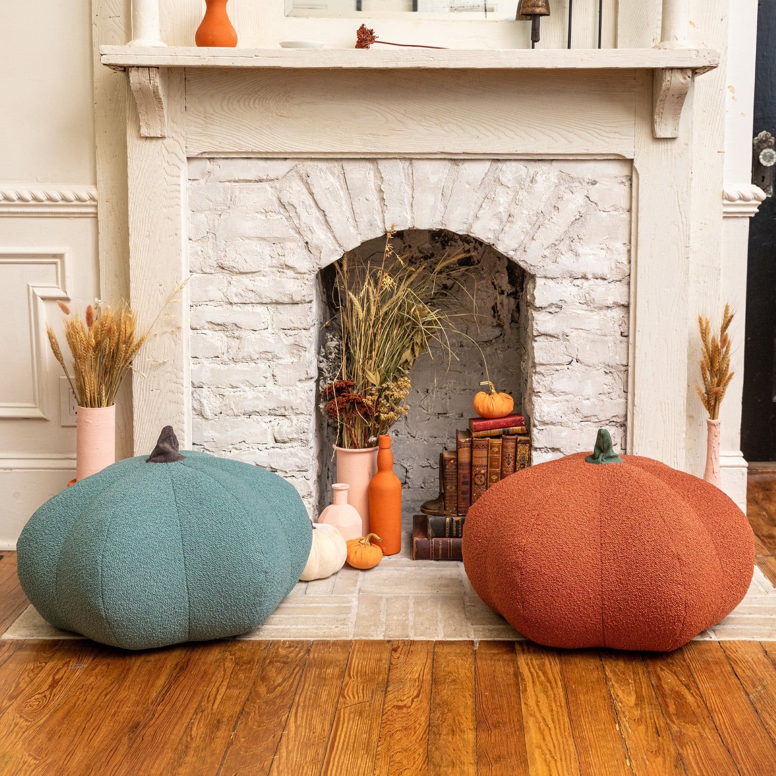 Green and orange Pumpkin Poufs sitting by fireplace