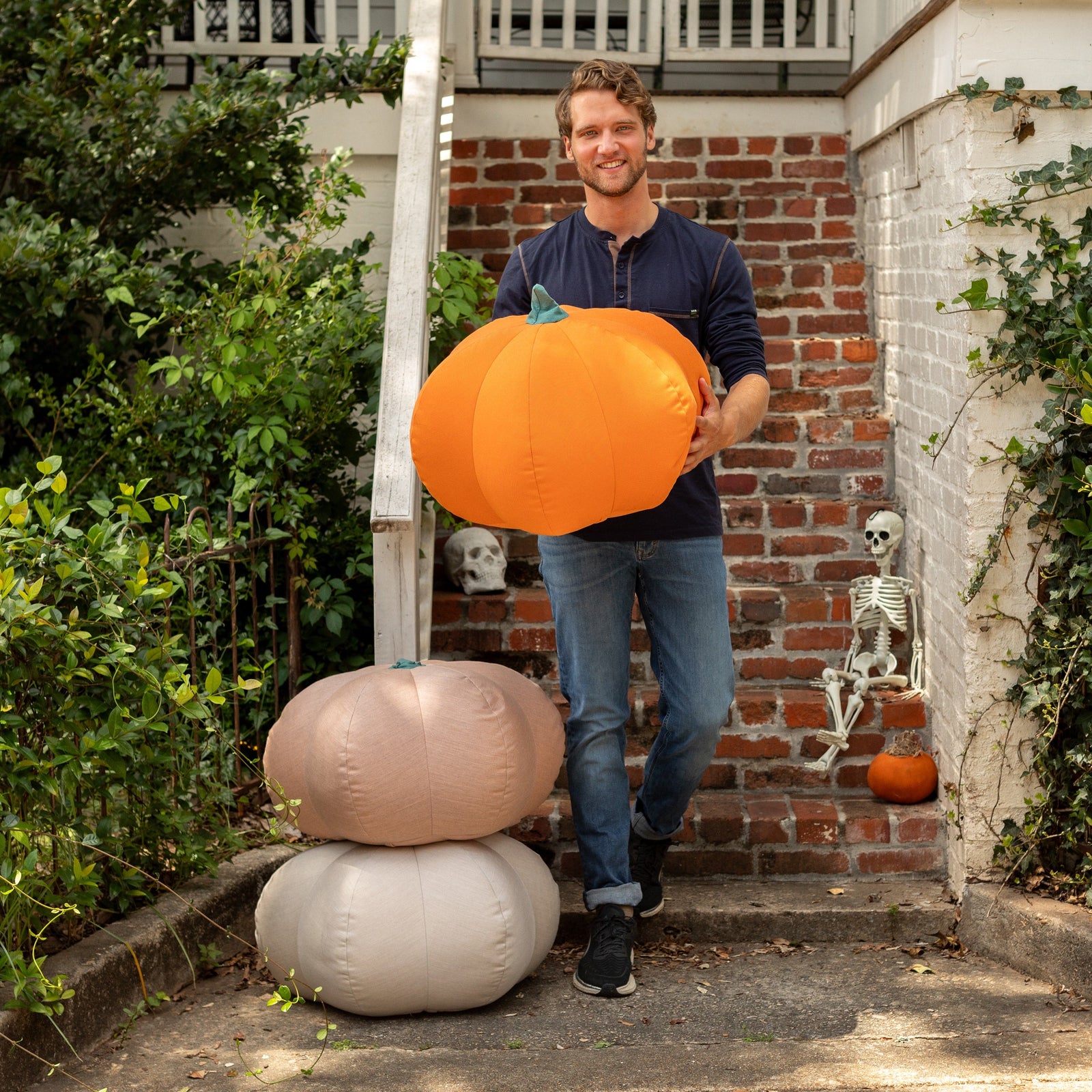 Man carrying orange Pumpkin Pouf down stairs