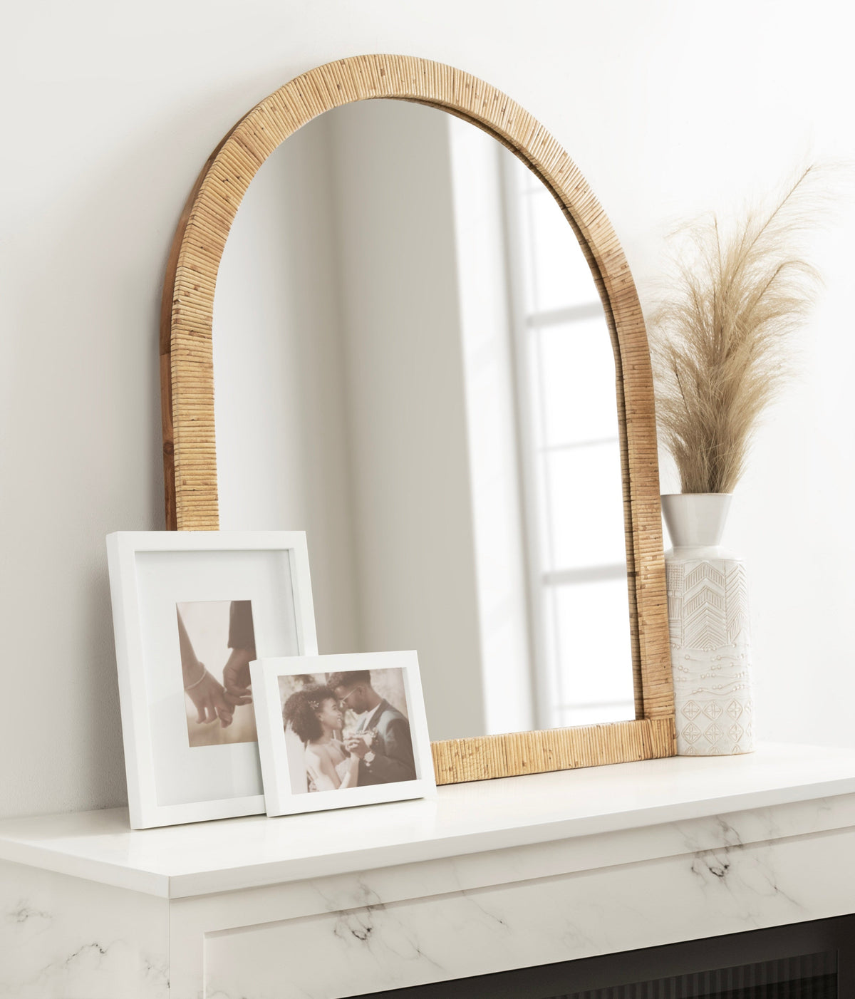 Natural rattan arch mirror on a dresser with decor