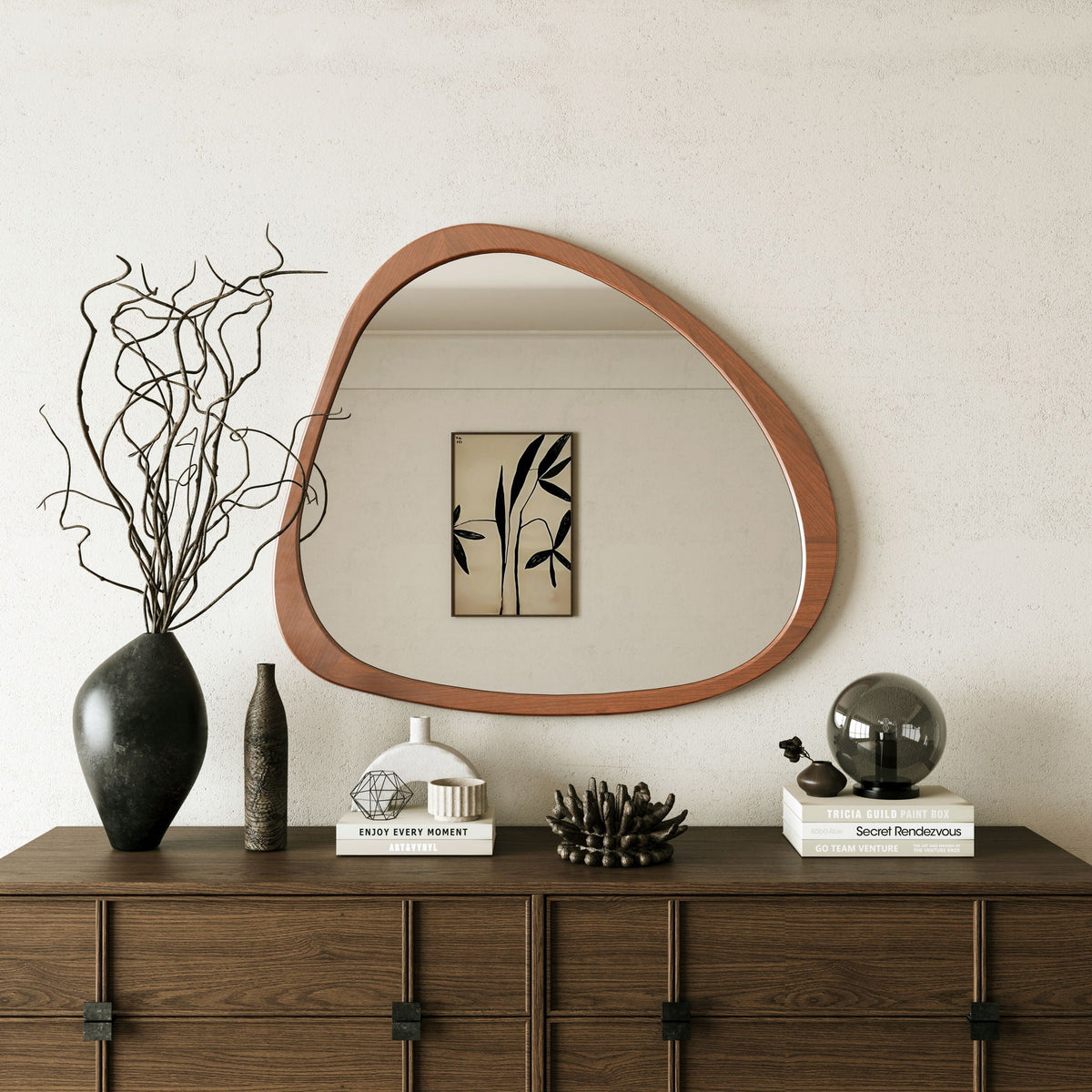 Asymmetrical wood wall mirror above a dark wood dresser