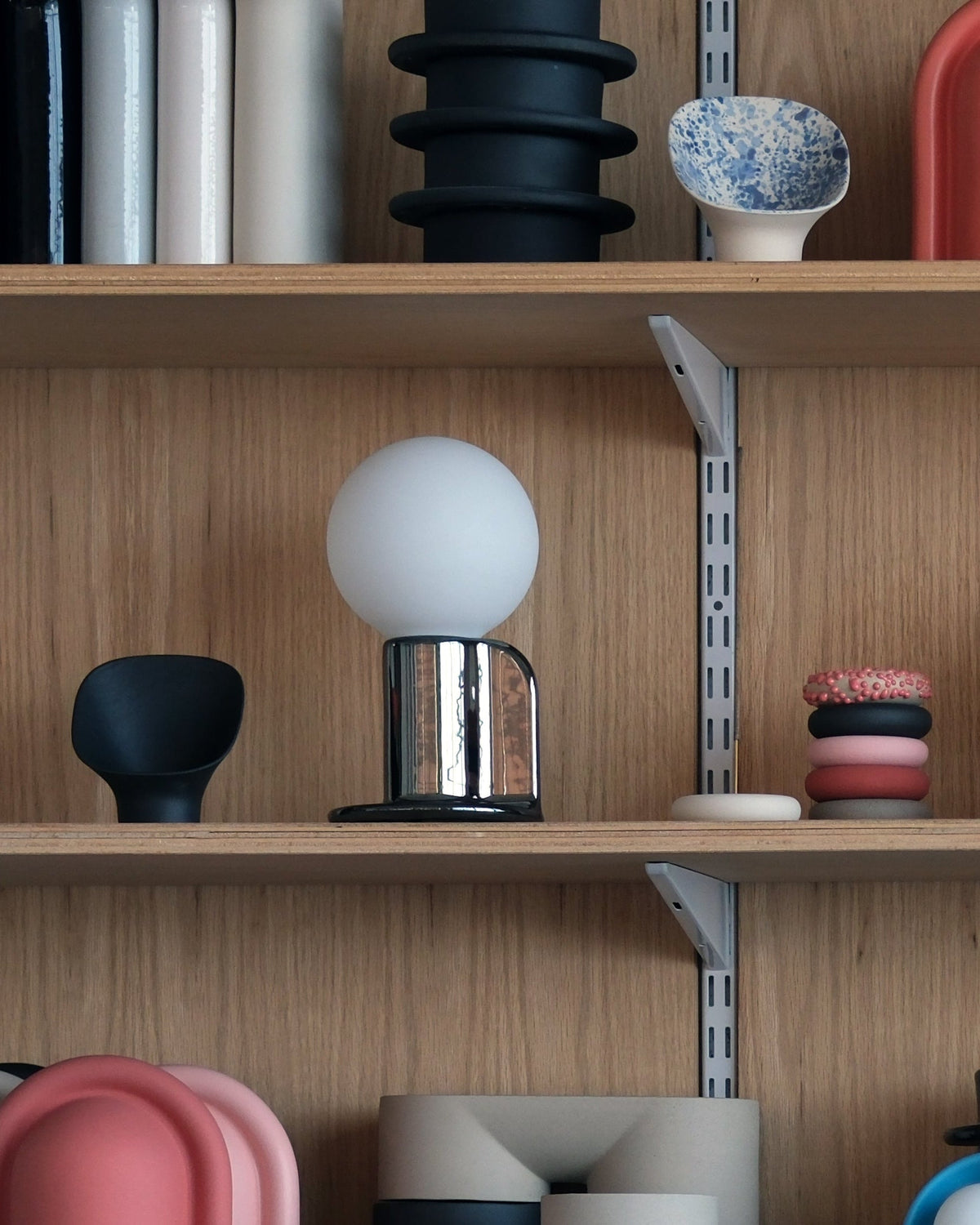 Q Lamp on a bookshelf with books and decor