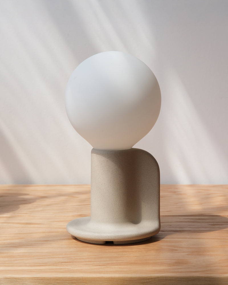 Q Lamp in white on a wood surface