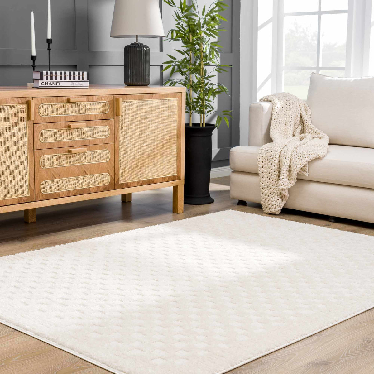 Ivory checkered rug with a cream sofa and wood console