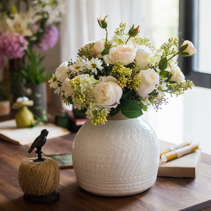White Glazed Ceramic Vase with white roses on a table