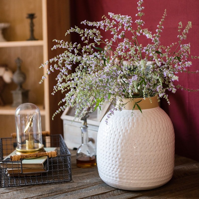 White Glazed Ceramic Vase with dried flowers on a table