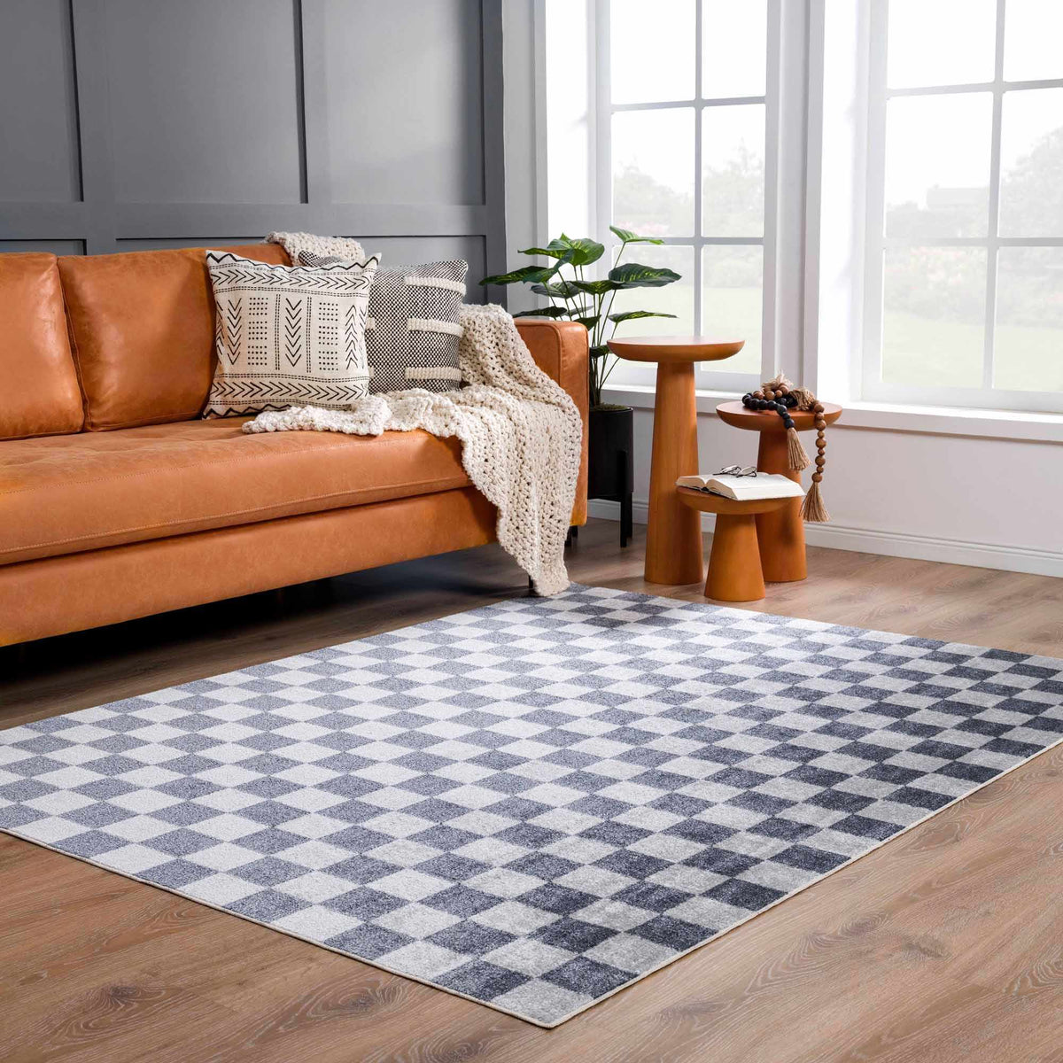 Alie checkered rug under an orange leather sofa