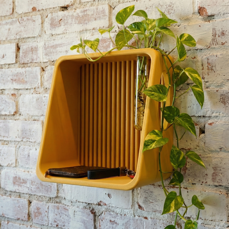 Ribbed Wall Shelf in mustard on a brick wall with a plant