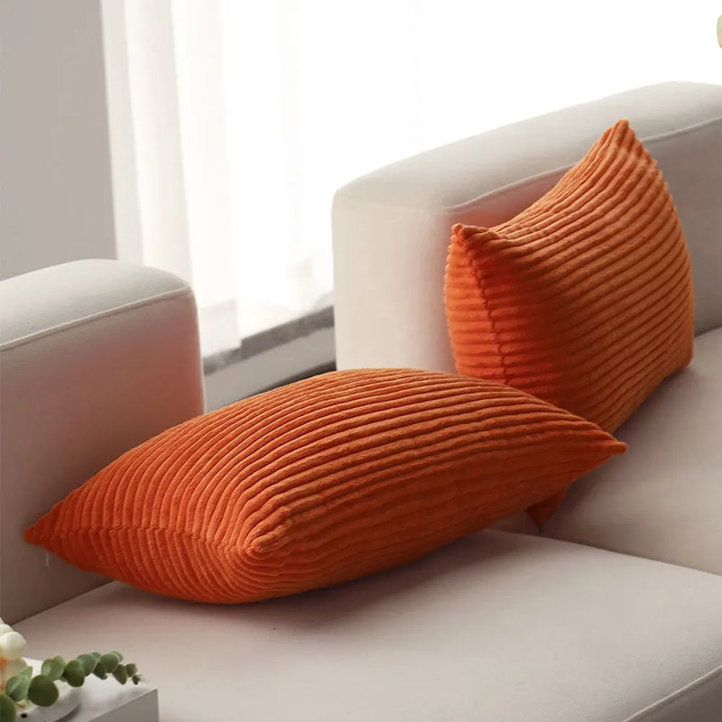 Corduroy Lumbar Pillow Cover in orange on a light sofa