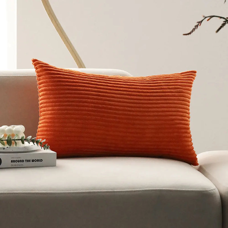 Orange corduroy lumbar pillow on a sofa