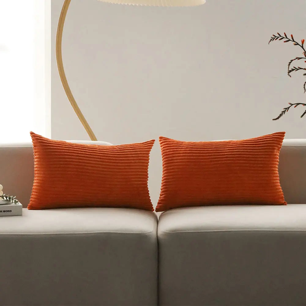 Pair of orange corduroy lumbar pillows on a sofa