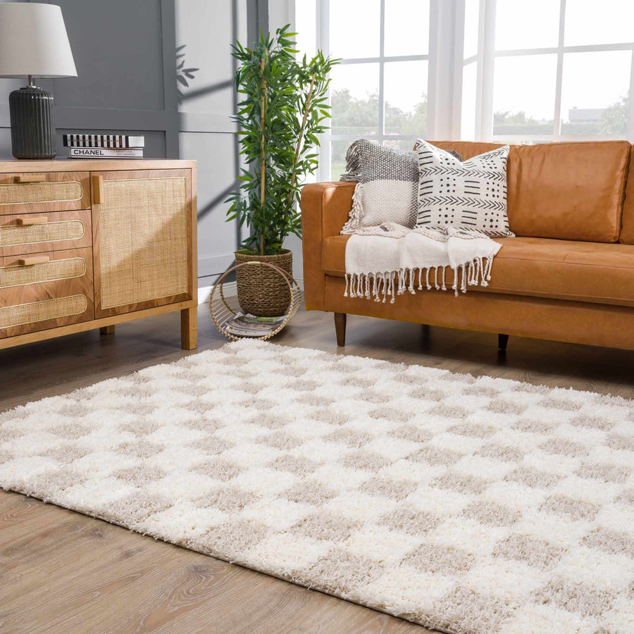 Cream checkered shag rug in a living room with a leather sofa