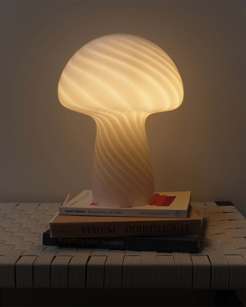 Mushroom Table Lamp lit on a stack of books