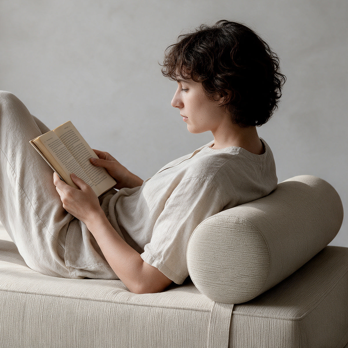 Alon Bolster Refresh in Ivory Microvelvet as a backrest for reading on the Alon Daybed