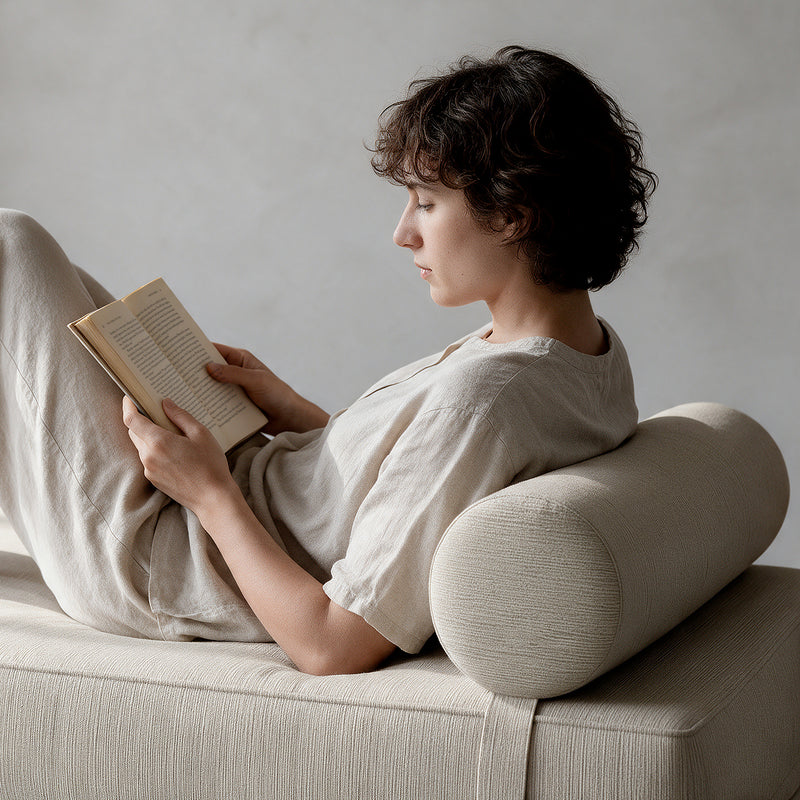 Alon Bolster Refresh in Ivory Microvelvet as a backrest for reading on the Alon Daybed