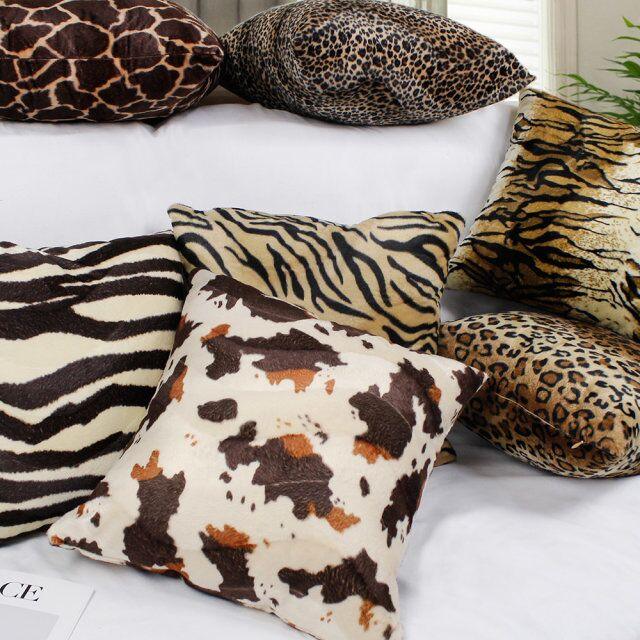 Plush cow print pillow covers on a sofa