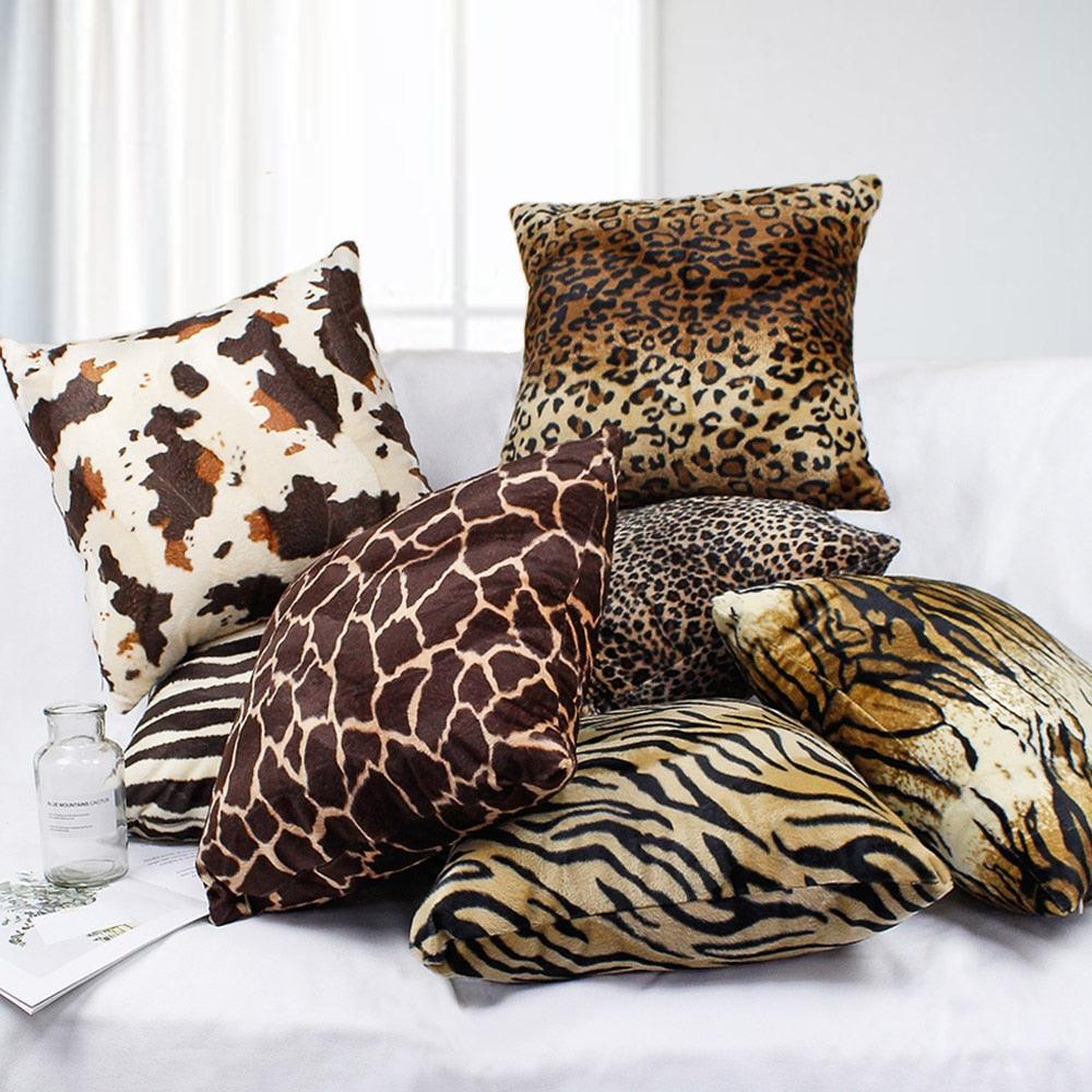 Plush animal print pillow covers in leopard, tiger and giraffe on a sofa