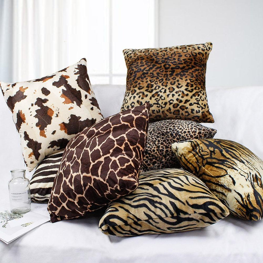 Plush animal print pillow covers in leopard, tiger and giraffe on a sofa