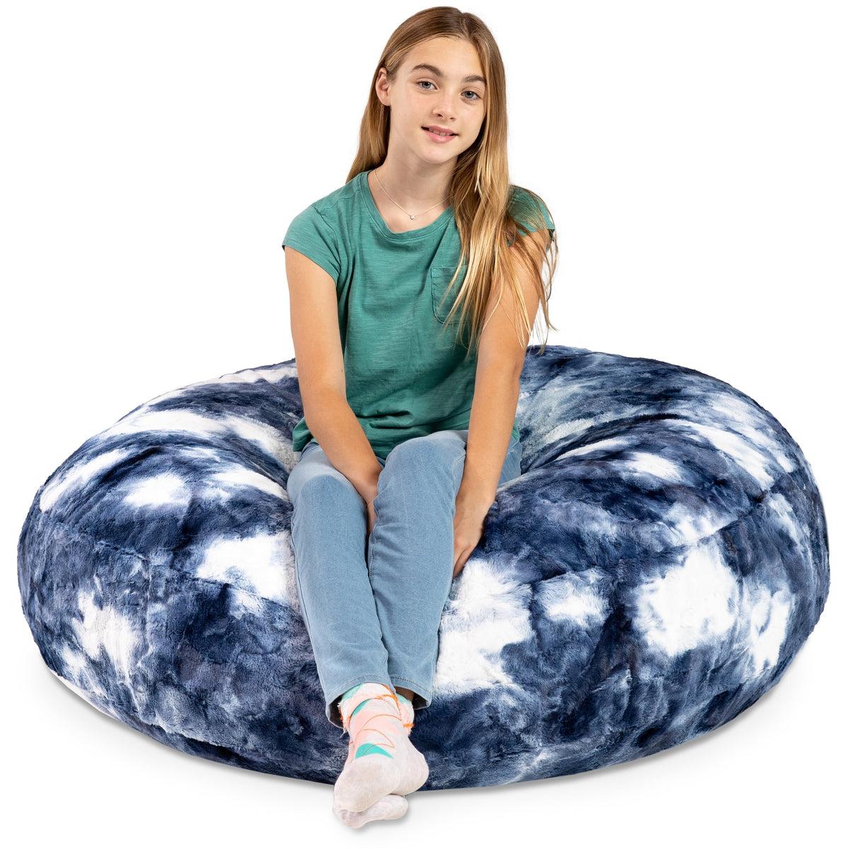 Person sitting on a large blue and white tie-dye bean bag chair against a white background
