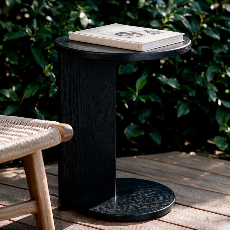 Black Echo Side Table on a patio with a book