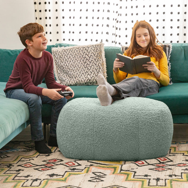 Children sitting on couch with Ellis Ottoman large in mineral green in living room