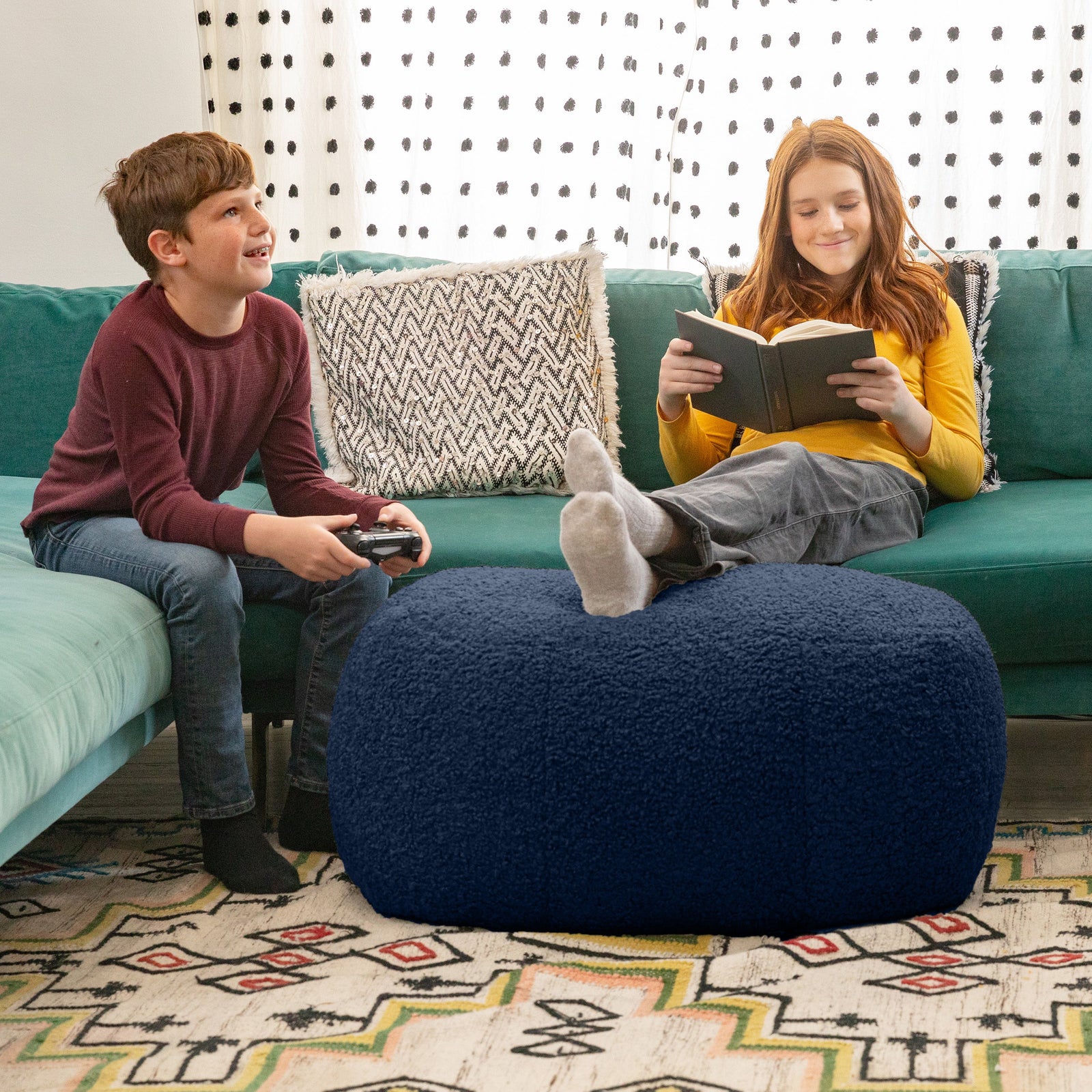 Children sitting on couch with Ellis Ottoman large in blue in living room