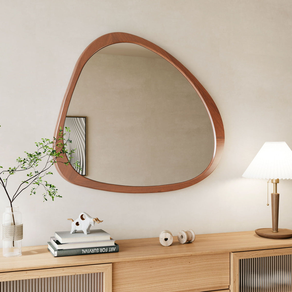 Asymmetrical wood wall mirror over a light wood sideboard