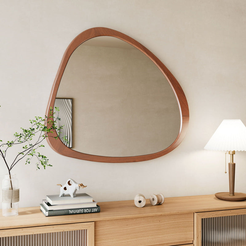 Asymmetrical wood wall mirror over a light wood sideboard