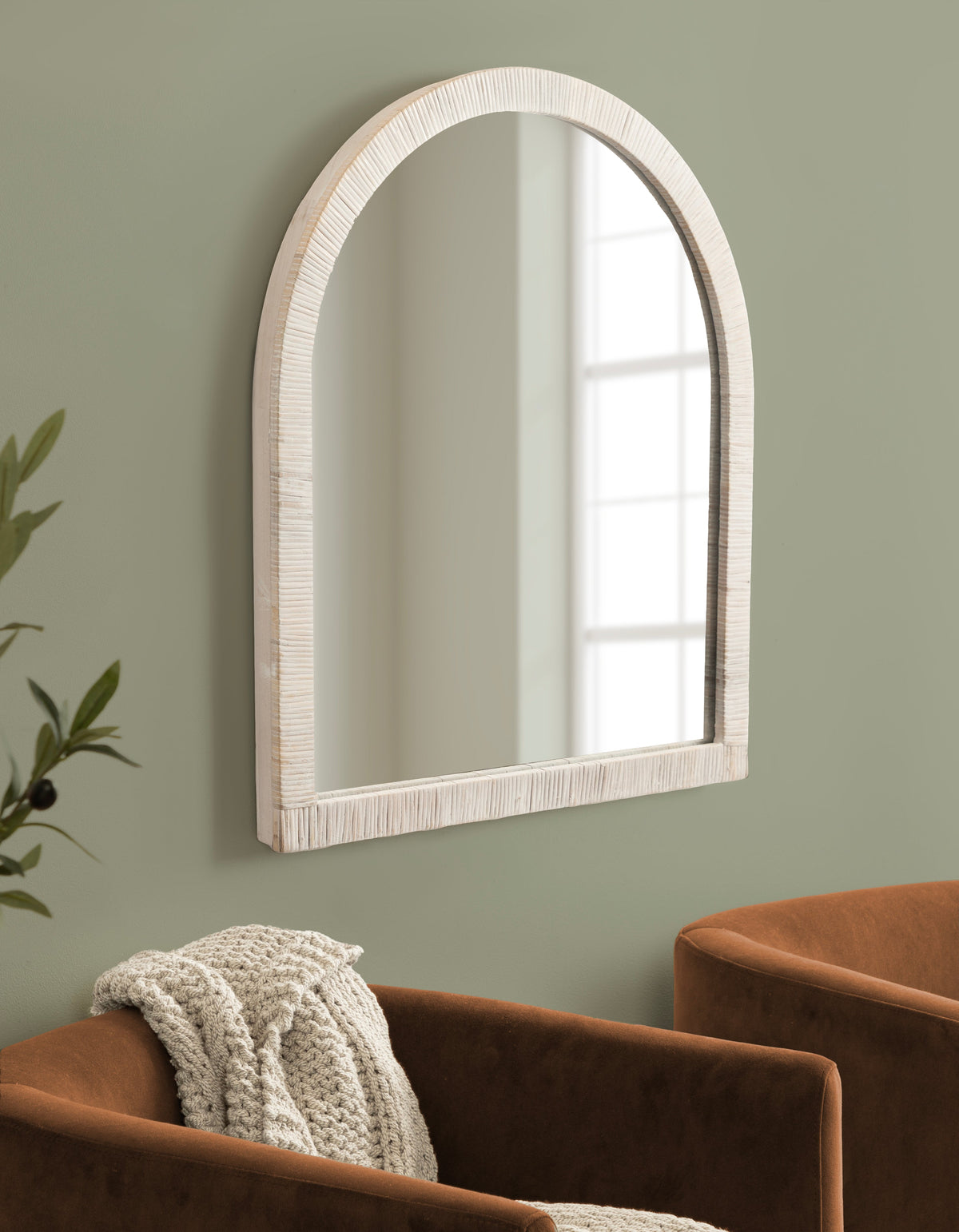 White rattan arch mirror in an entryway