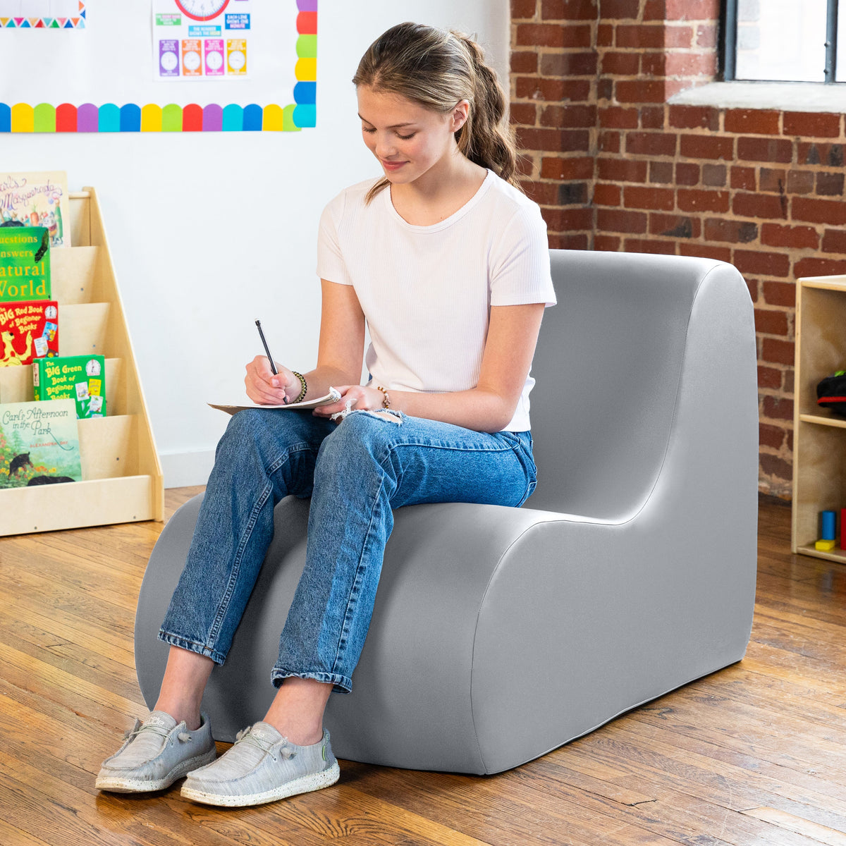 Girl sitting in Midtown chair in gray in a classroom