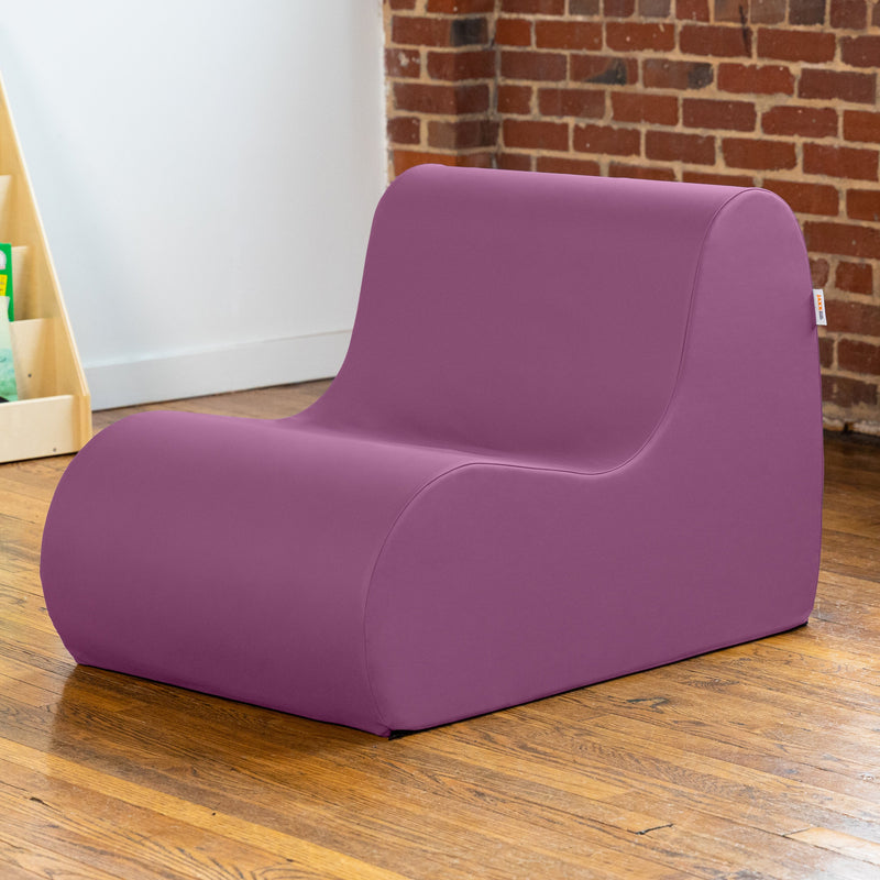 Purple chair on a wooden floor with a brick wall background